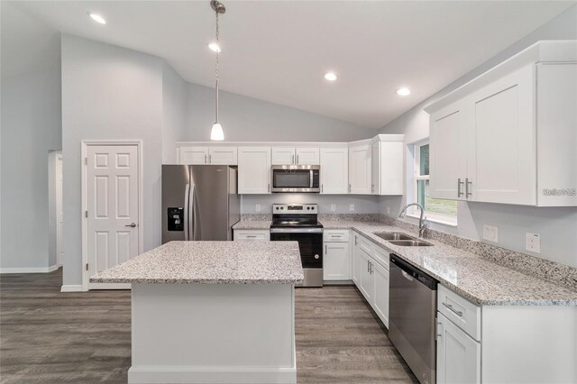 kitchen with a kitchen island, pendant lighting, stainless steel appliances, lofted ceiling, and sink