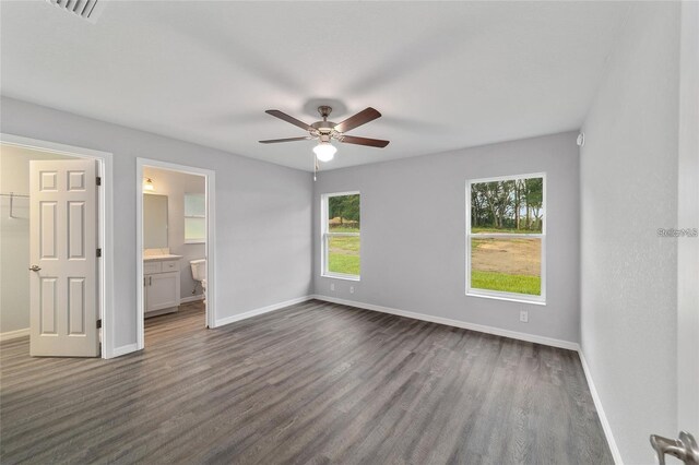 unfurnished bedroom with connected bathroom, dark hardwood / wood-style flooring, and ceiling fan