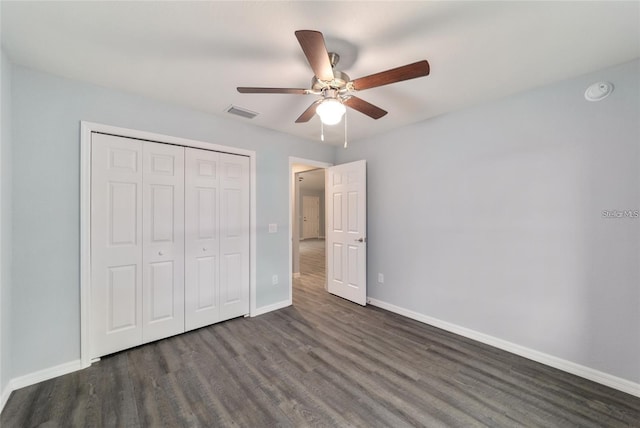 unfurnished bedroom featuring ceiling fan, dark wood-type flooring, and a closet