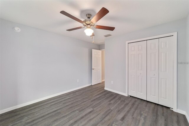 unfurnished bedroom featuring a closet, ceiling fan, and dark wood-type flooring