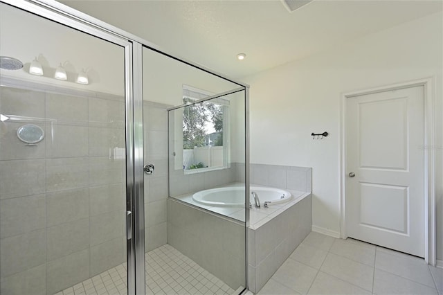 bathroom with a bath, a shower stall, and tile patterned floors