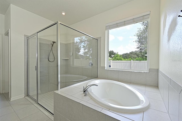 bathroom featuring a garden tub, tile patterned floors, and a stall shower