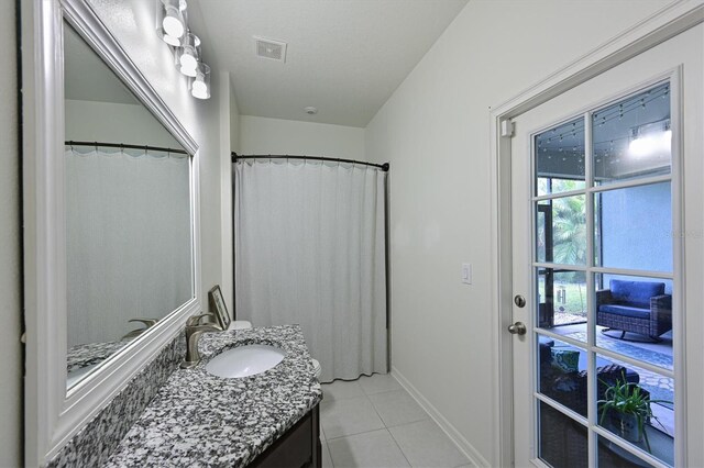 bathroom with a shower with shower curtain, vanity, and tile patterned floors