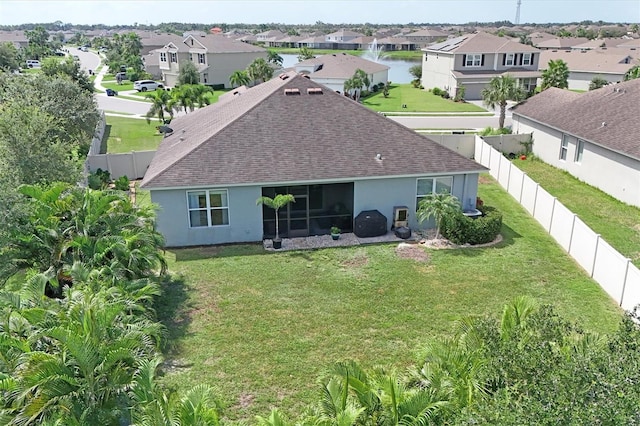 back of house with a residential view, a shingled roof, a fenced backyard, and stucco siding
