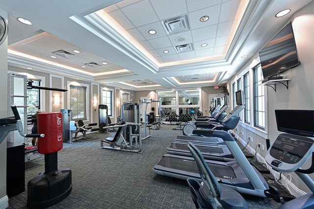 gym featuring a raised ceiling