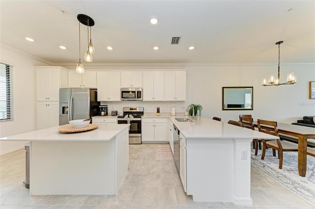 kitchen featuring sink, white cabinets, a kitchen island, stainless steel appliances, and decorative light fixtures