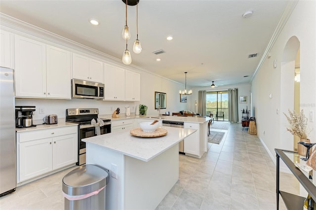 kitchen with appliances with stainless steel finishes, kitchen peninsula, and white cabinets