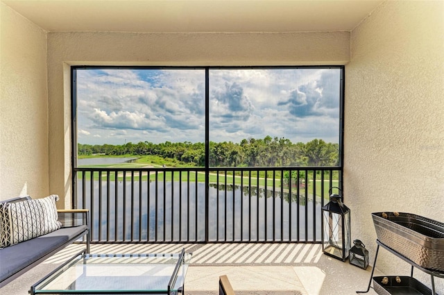 sunroom featuring a water view