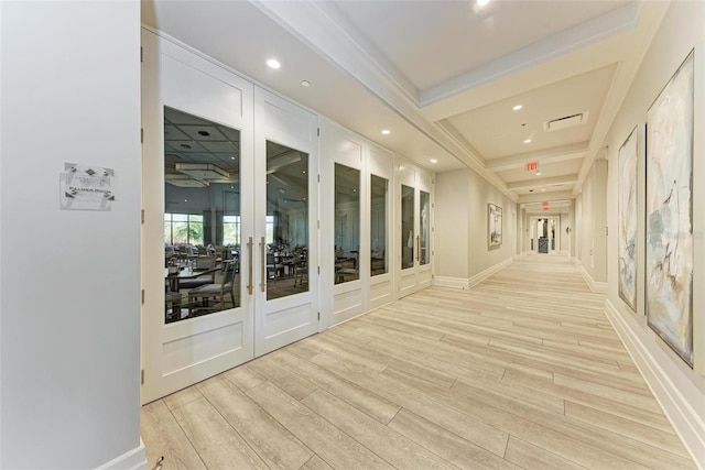 corridor with beam ceiling, coffered ceiling, light hardwood / wood-style flooring, and french doors