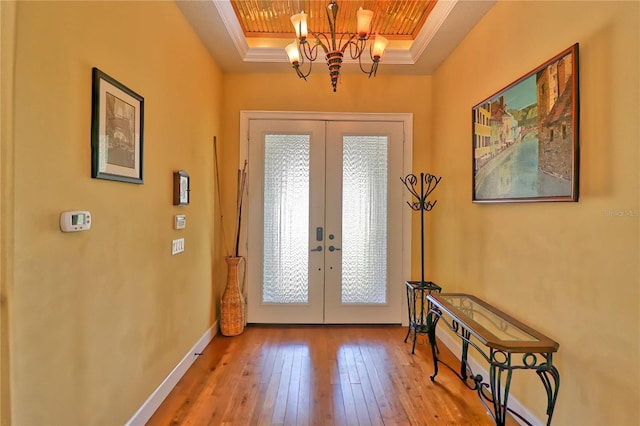 entryway with a raised ceiling, french doors, and hardwood / wood-style flooring