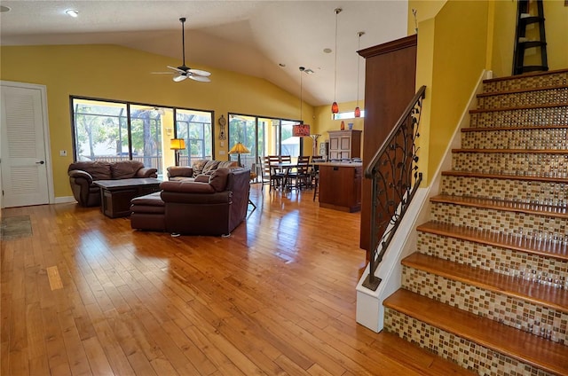 living room with high vaulted ceiling, light wood-type flooring, and ceiling fan