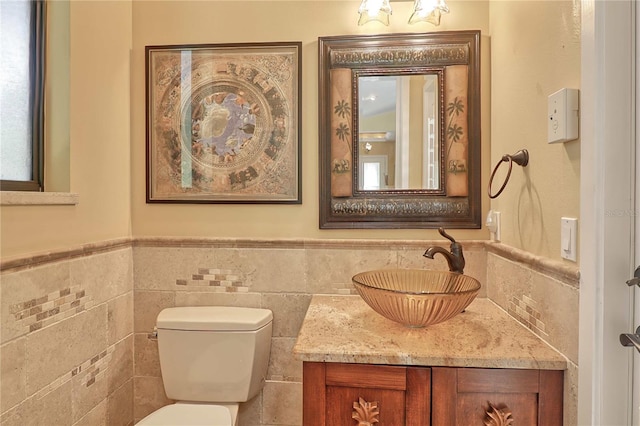 bathroom with tile walls, vanity, and toilet