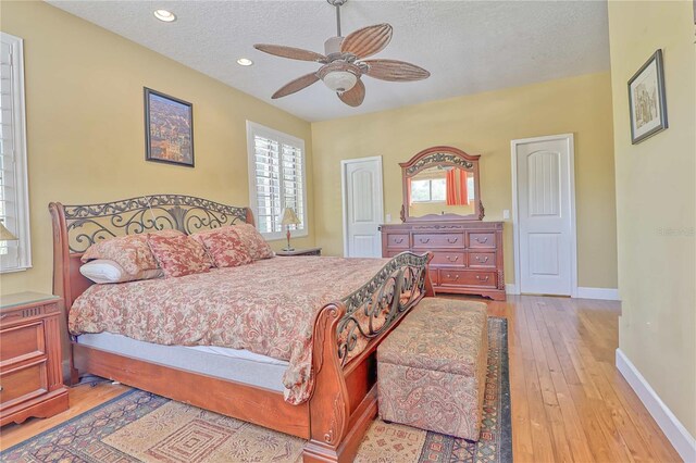 bedroom featuring ceiling fan, a textured ceiling, and light hardwood / wood-style floors