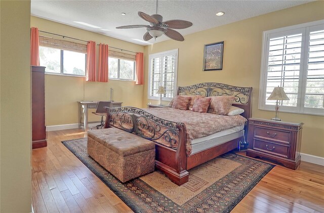 bedroom featuring light hardwood / wood-style flooring, multiple windows, and ceiling fan