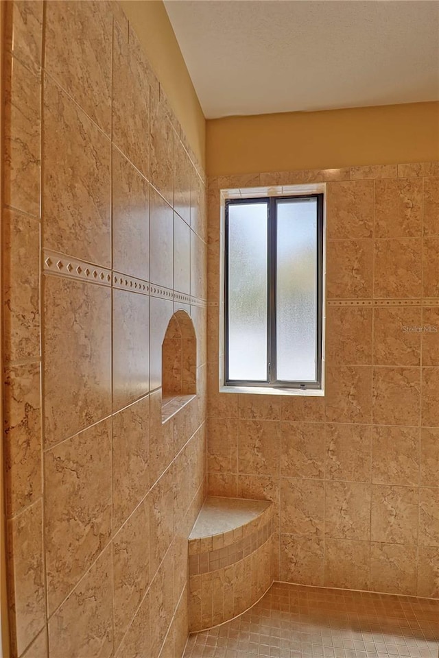 bathroom with a tile shower and tile patterned floors