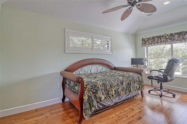 bedroom featuring ceiling fan, hardwood / wood-style floors, and a textured ceiling