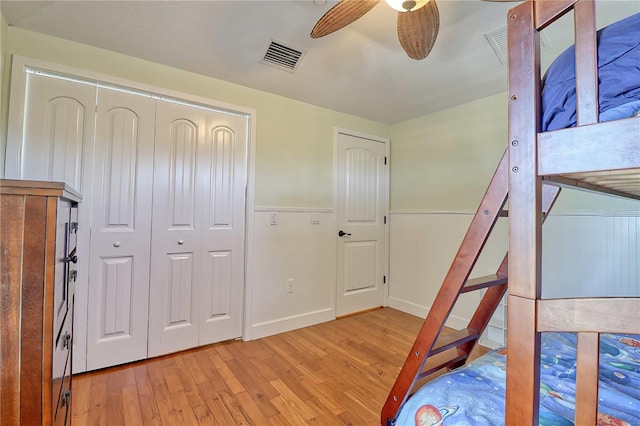 bedroom featuring ceiling fan, light hardwood / wood-style flooring, and a closet