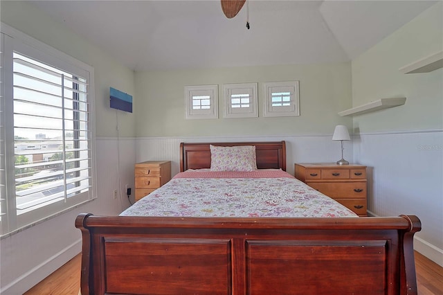 bedroom with ceiling fan, lofted ceiling, and light hardwood / wood-style floors