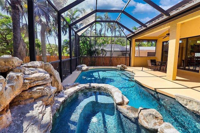 view of swimming pool featuring a patio, an in ground hot tub, and a lanai