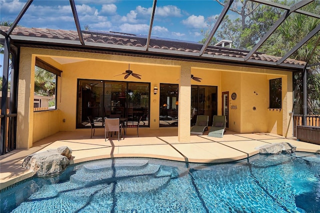 view of pool with glass enclosure, ceiling fan, and a patio area