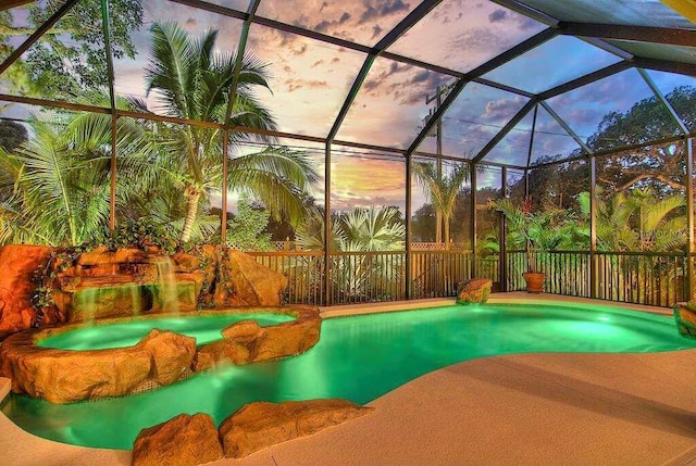 pool at dusk featuring a lanai