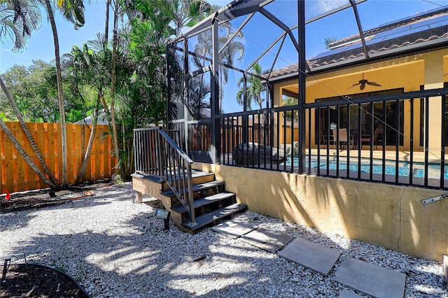 view of patio with glass enclosure, ceiling fan, and a fenced in pool