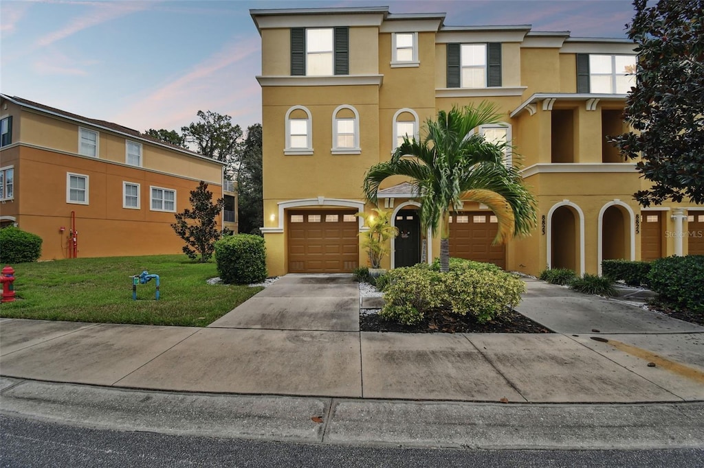 view of front of home with a yard and a garage