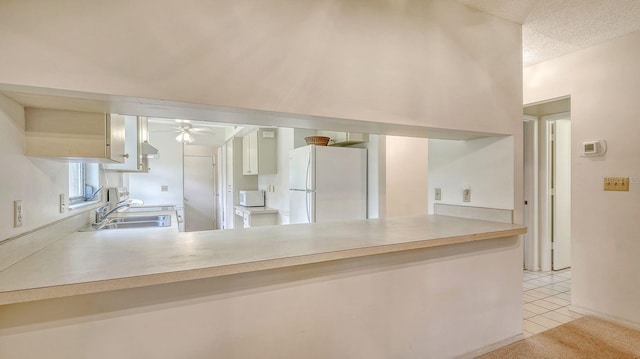 kitchen with white appliances, light tile patterned flooring, ceiling fan, and kitchen peninsula