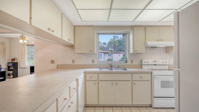 kitchen with white appliances, kitchen peninsula, ceiling fan, cream cabinets, and sink