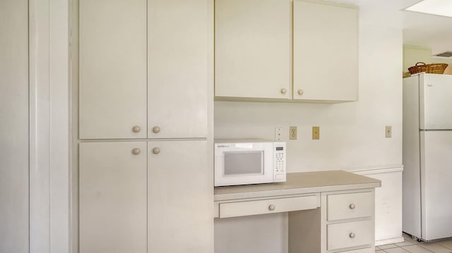 kitchen with white appliances and light tile patterned floors