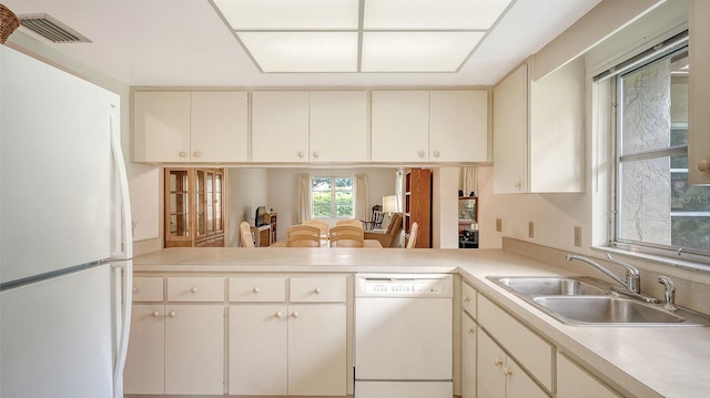 kitchen featuring white appliances, sink, and kitchen peninsula