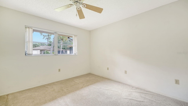 carpeted spare room with ceiling fan and a textured ceiling