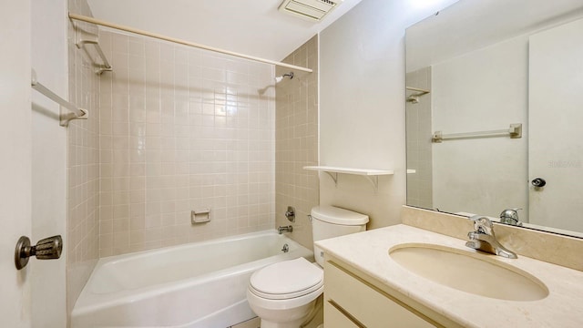 full bathroom with tiled shower / bath, vanity, and toilet