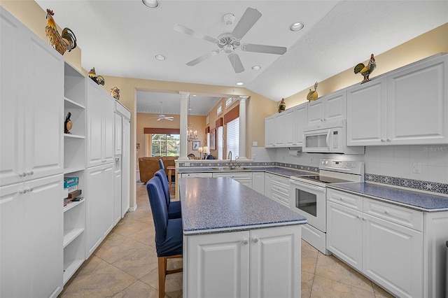 kitchen with white cabinets, white appliances, a center island, ceiling fan, and sink