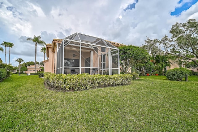 back of house with a yard and glass enclosure