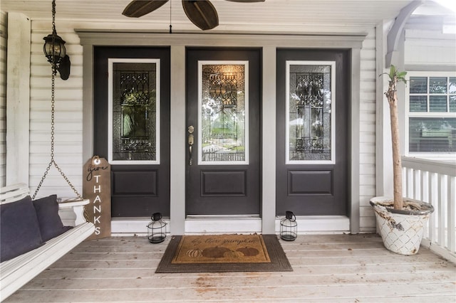 entrance to property featuring ceiling fan and a porch