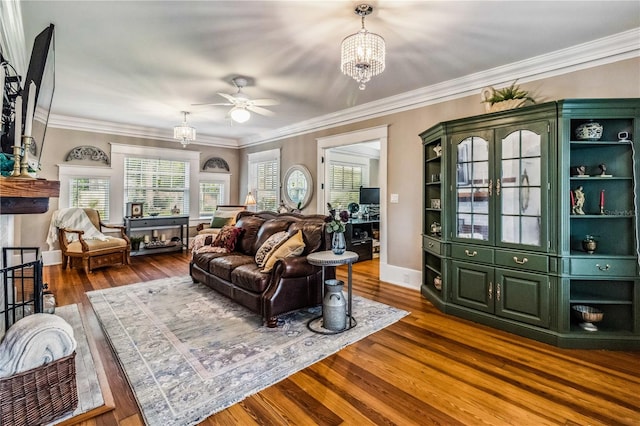 living room with ceiling fan with notable chandelier, ornamental molding, and hardwood / wood-style flooring