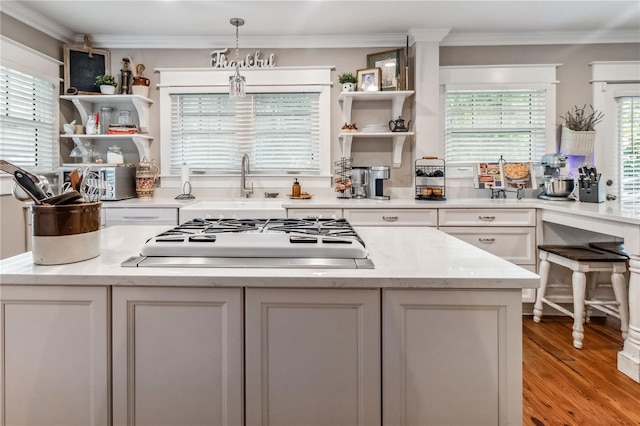 kitchen featuring light wood-type flooring, a healthy amount of sunlight, white cabinetry, and pendant lighting