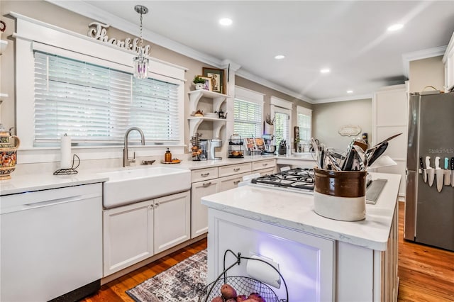 kitchen featuring pendant lighting, sink, white cabinets, white dishwasher, and stainless steel fridge