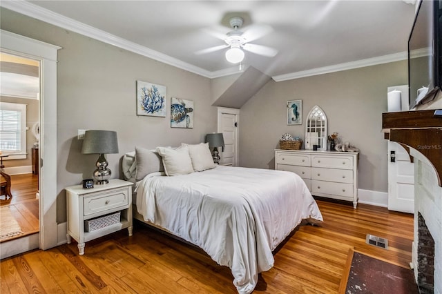 bedroom with light wood-type flooring, crown molding, and ceiling fan