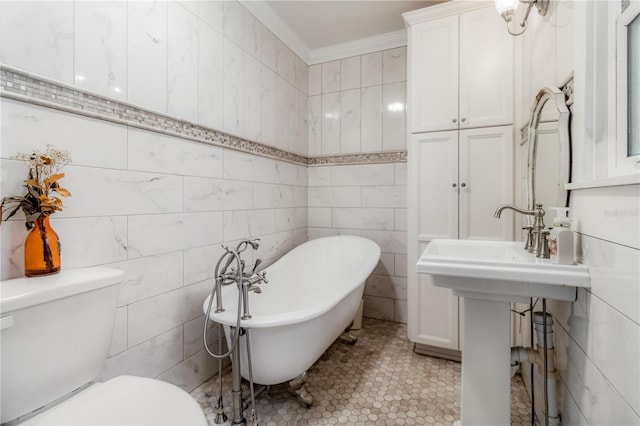 bathroom featuring crown molding, a tub, toilet, and tile patterned floors