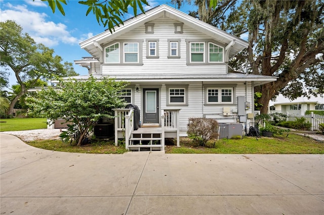 view of front of house with central AC unit and a front yard