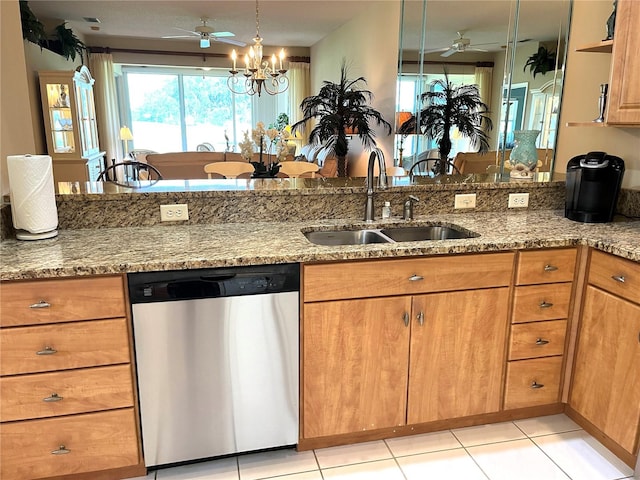 kitchen with light stone counters, light tile patterned flooring, sink, dishwasher, and ceiling fan with notable chandelier