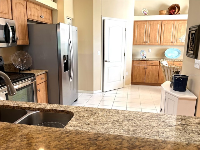 kitchen with appliances with stainless steel finishes, sink, and light tile patterned floors