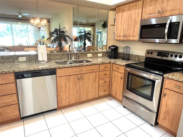 kitchen featuring ceiling fan with notable chandelier, light tile patterned flooring, appliances with stainless steel finishes, and sink