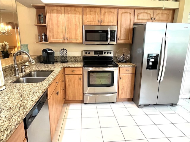 kitchen featuring light stone counters, light tile patterned floors, stainless steel appliances, an inviting chandelier, and sink