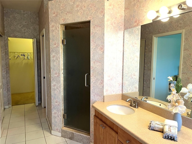 bathroom featuring tile patterned flooring, an enclosed shower, and vanity