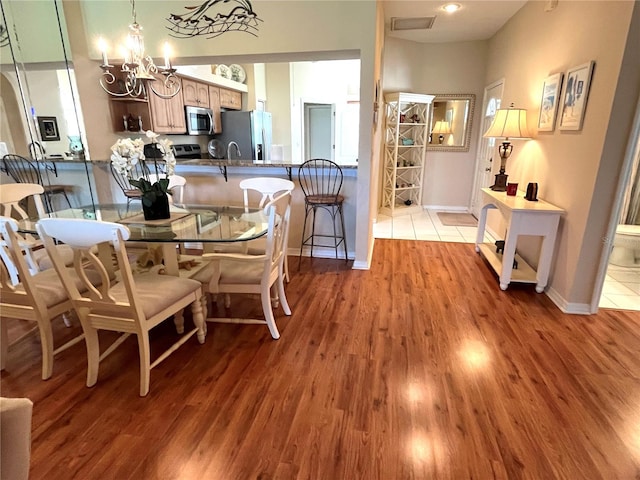 dining area featuring light hardwood / wood-style floors and a notable chandelier