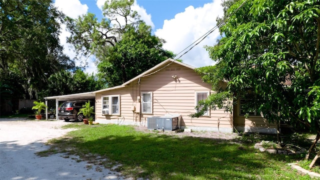 1820 7th Ave E, Bradenton, FL 34208 - back of property featuring an attached carport, dirt driveway, cooling unit, and a yard
