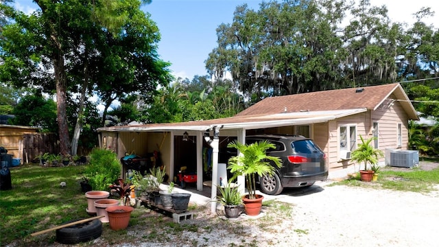 exterior space featuring central AC unit, a front lawn, and a carport